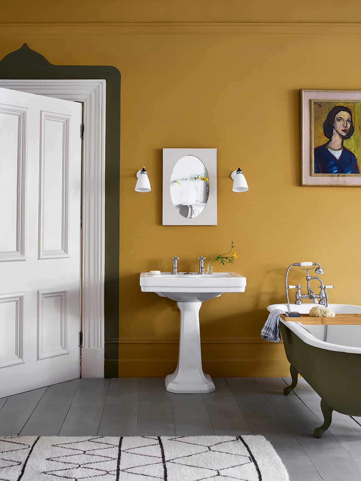 A traditional bathroom with mustard walls and grey painted floorboards