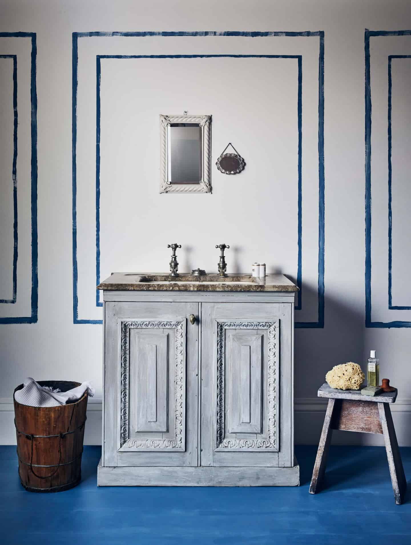 An ornate bathroom vanity unit on dark blue painted floorboards