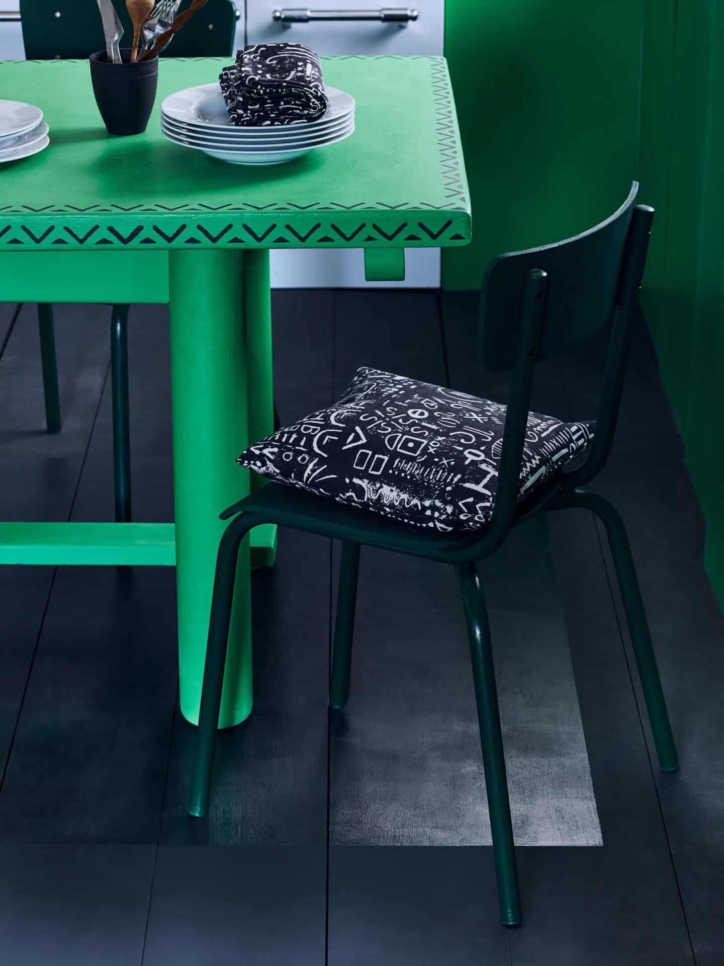 A painted green kitchen table on black painted floorboards