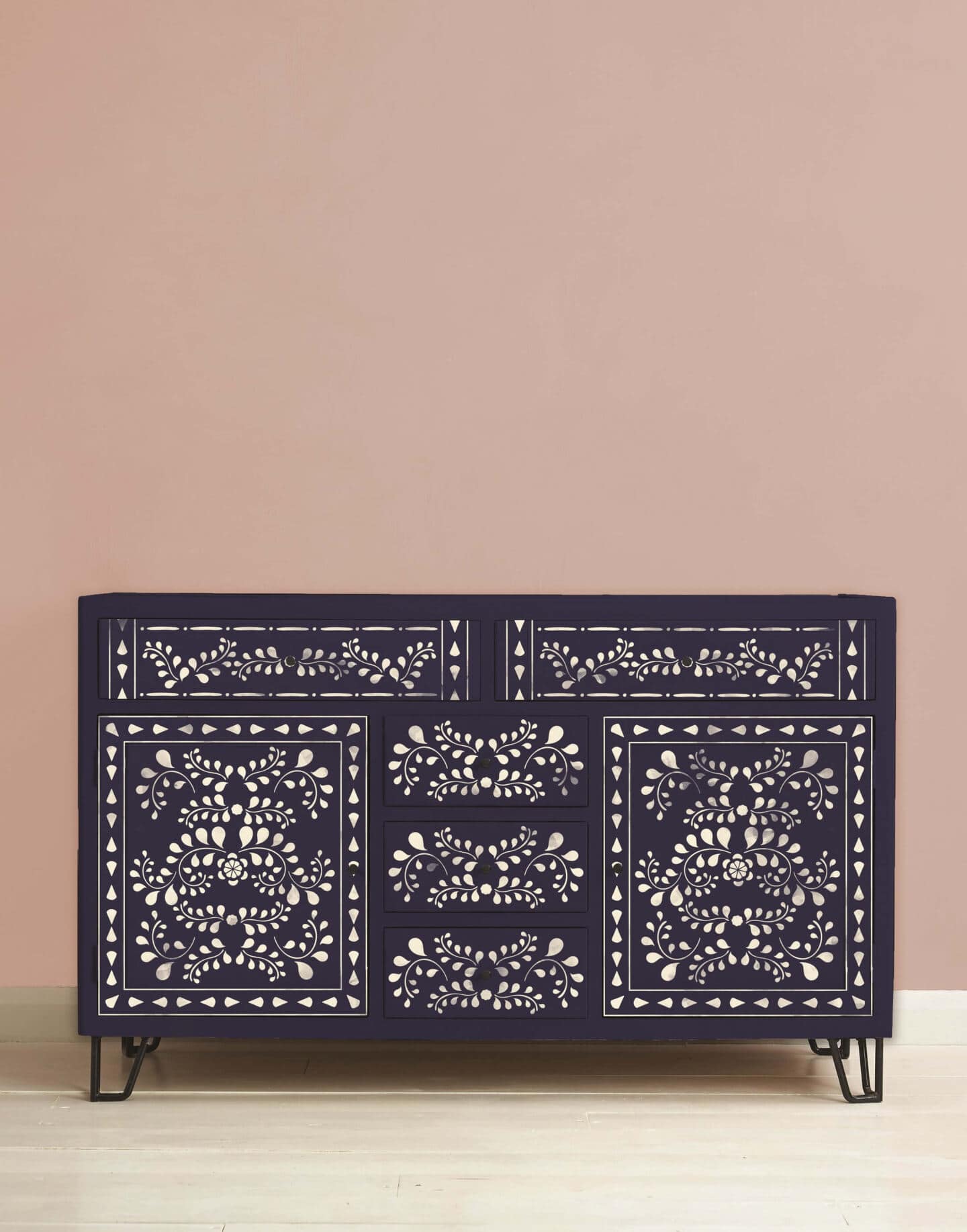 A sideboard upcycled with purple paint from Annie Sloane and white floral patterns stencilled onto the front