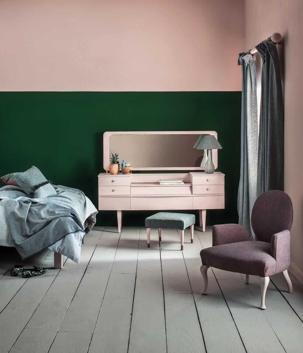 A green and pink bedroom with grey painted floorboards