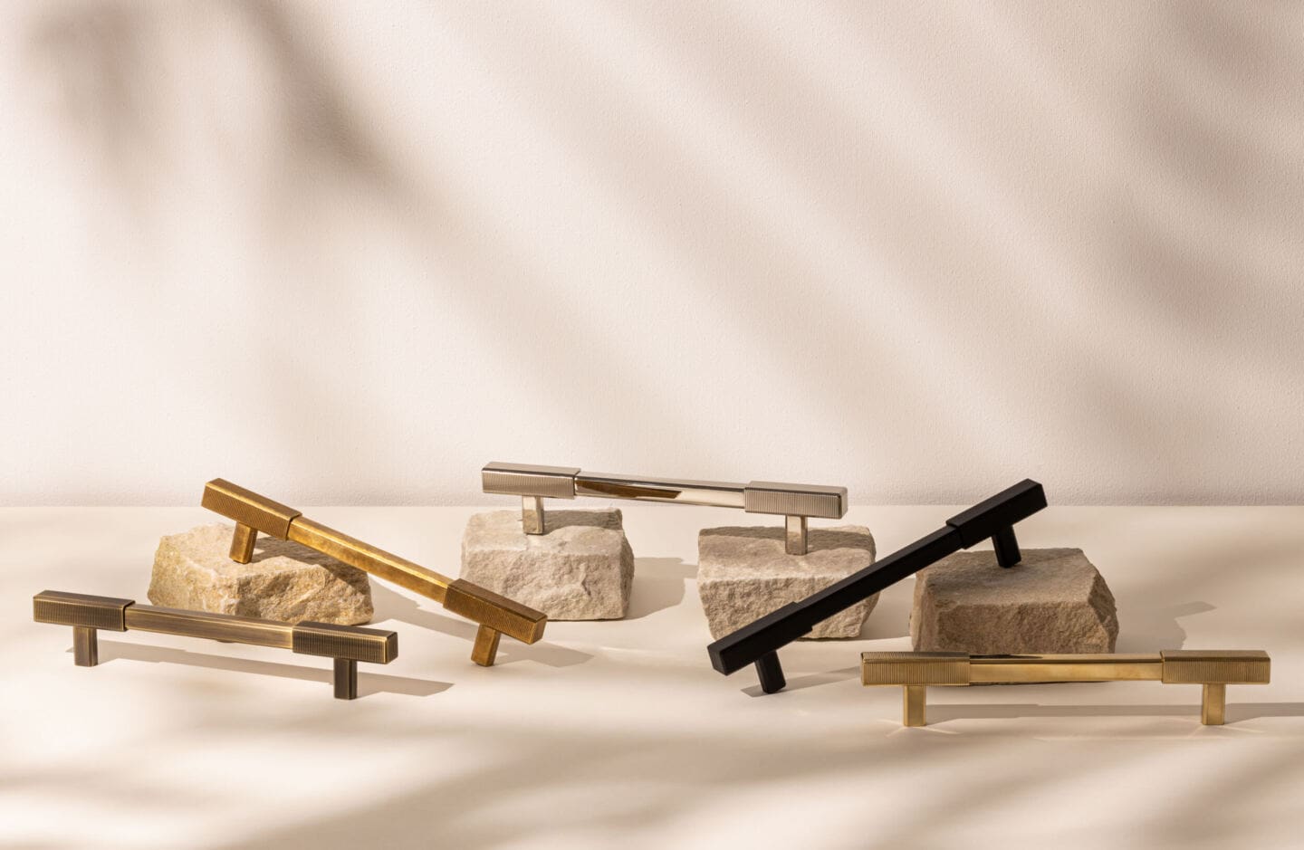 A range of door pulls from Armac Martin balanced artistically on little pieces of stone
