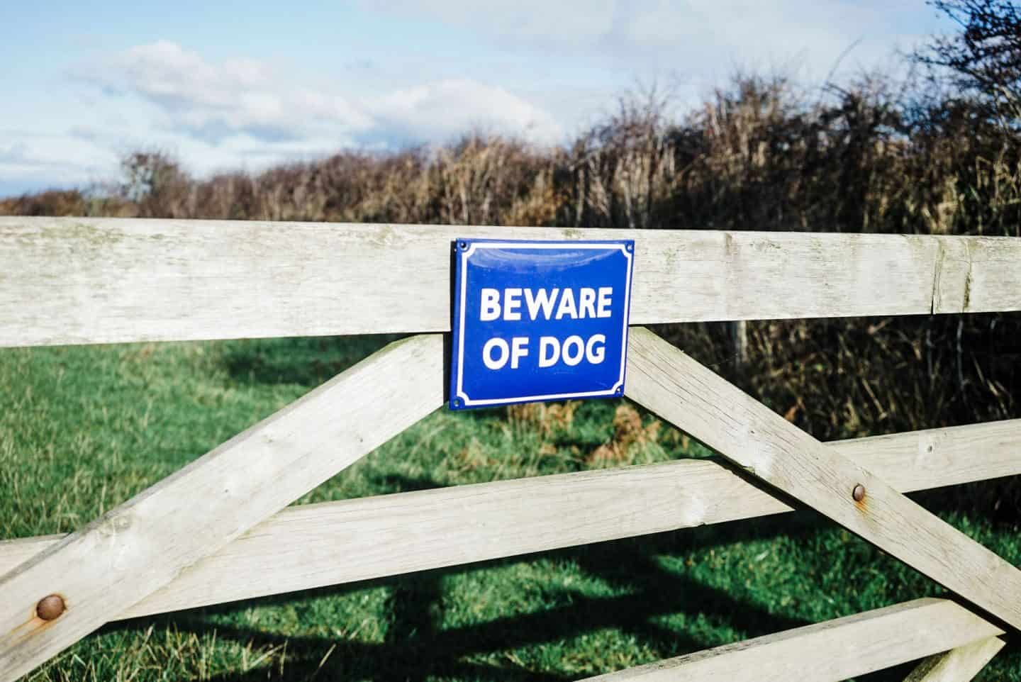 Beware of dog enamel signs from Ramsign seen on a gate in a field