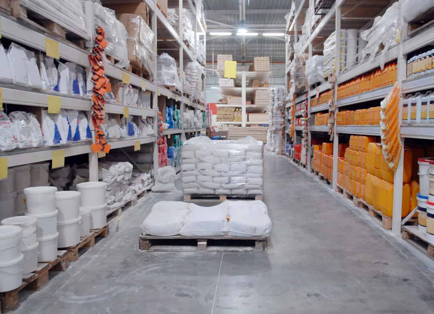 Inside a hardware store. Shelves full of renovation materials and pallets on the floor