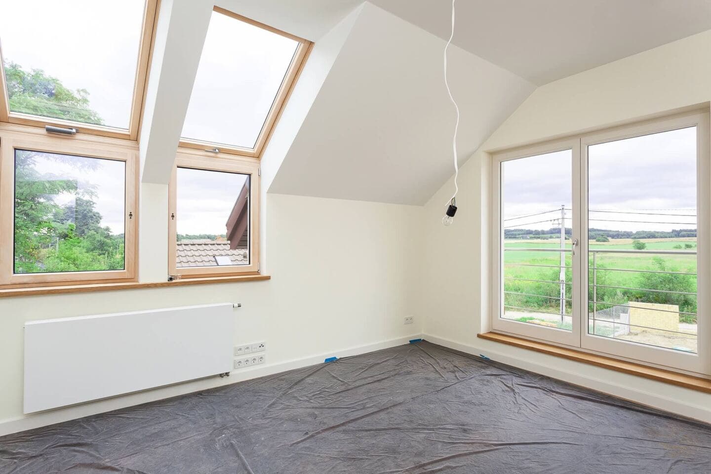 An empty room in a modern home with double aspect windows that has just been renovated