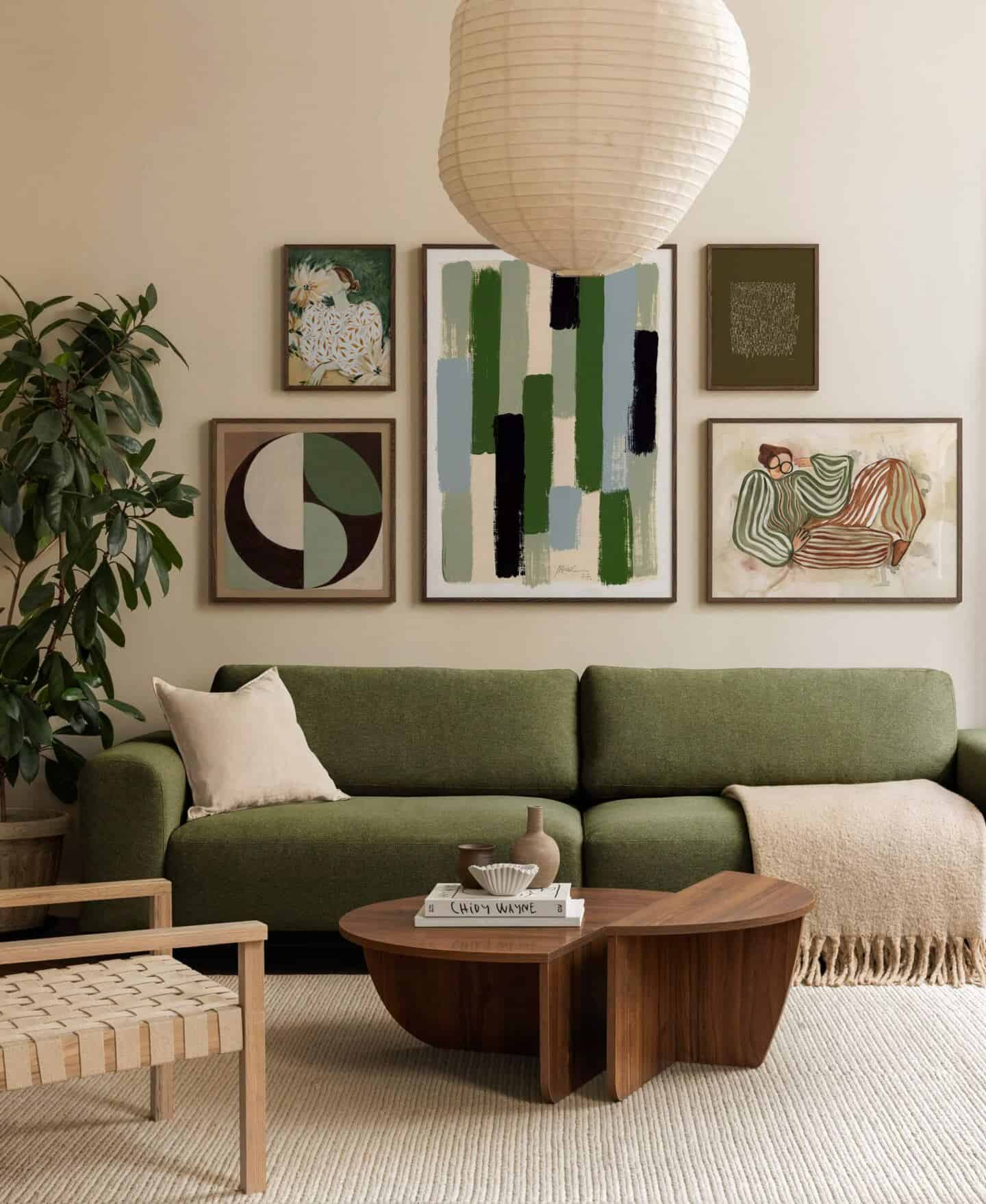 A gallery wall of abstract art behind a green sofa