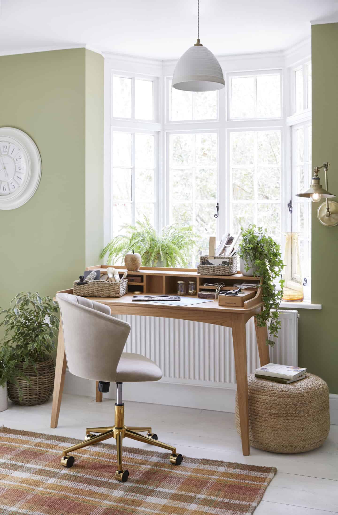 A wooden desk placed in front of a window bathed in natural light creates a productive home office