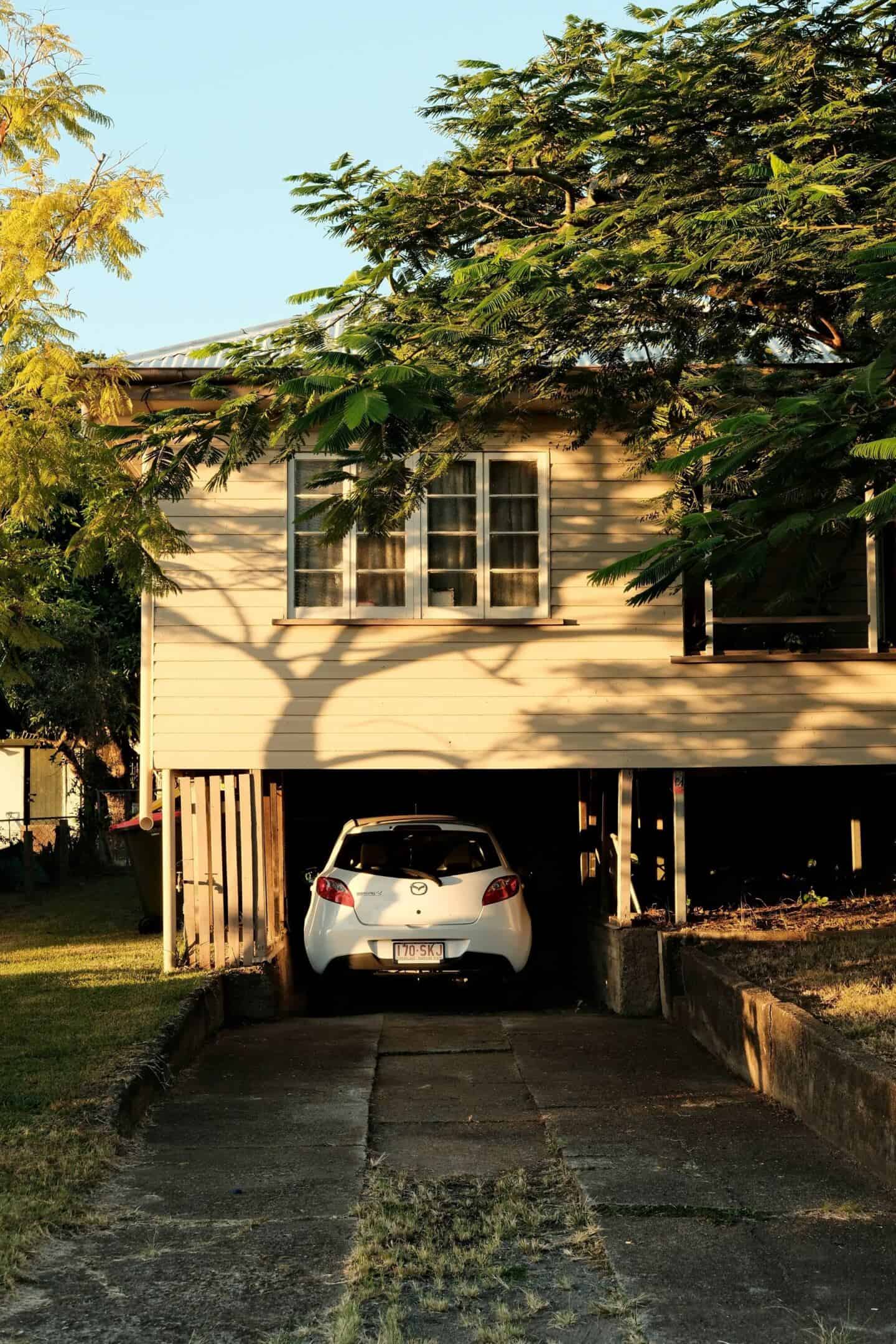 A detached home with an integrated garage with a car parked in it.