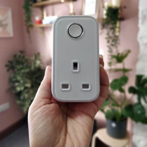 a female hand holding a Hive smart plug