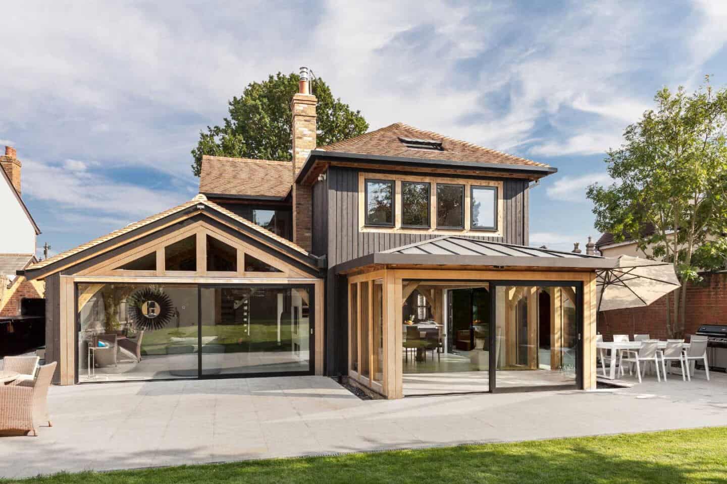 A detached home that maximises natural light with a timber frame extension and black aluminium sliding doors and windows.
