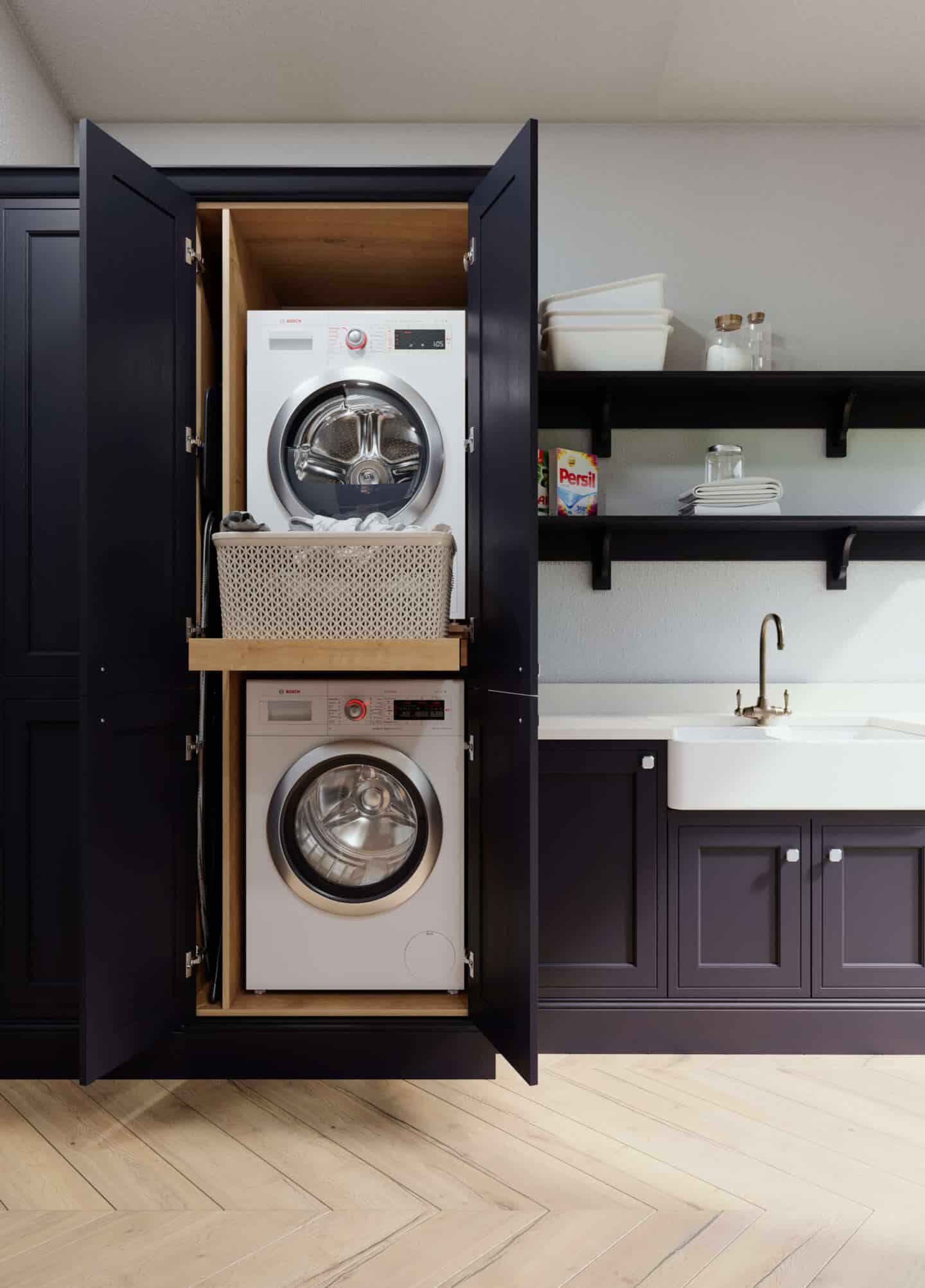 An indigo utility room with stacked washing machine and tumble dryer with pull out shelf between and a Belfast sink