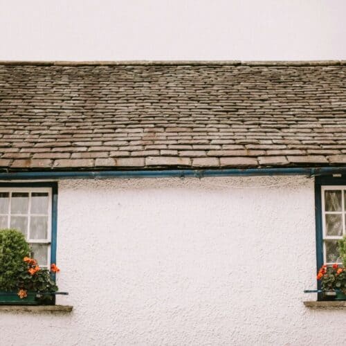 A traditional white cottage with a slate roof