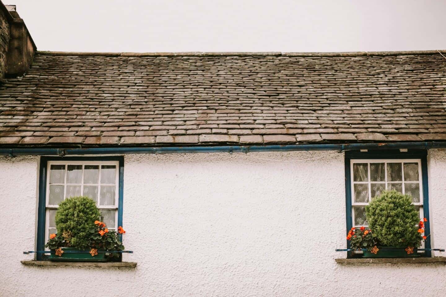 A traditional white cottage with a slate roof