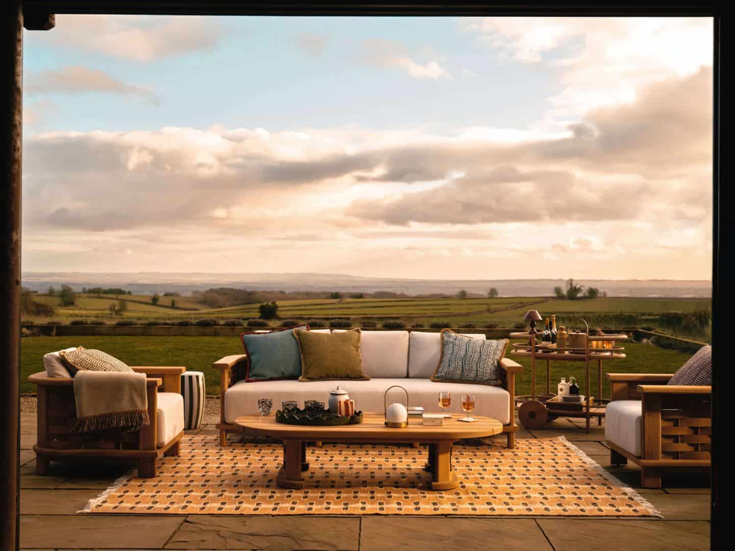 A garden sofa set with coffee table and outdoor rug creates the perfect indoor outdoor living room