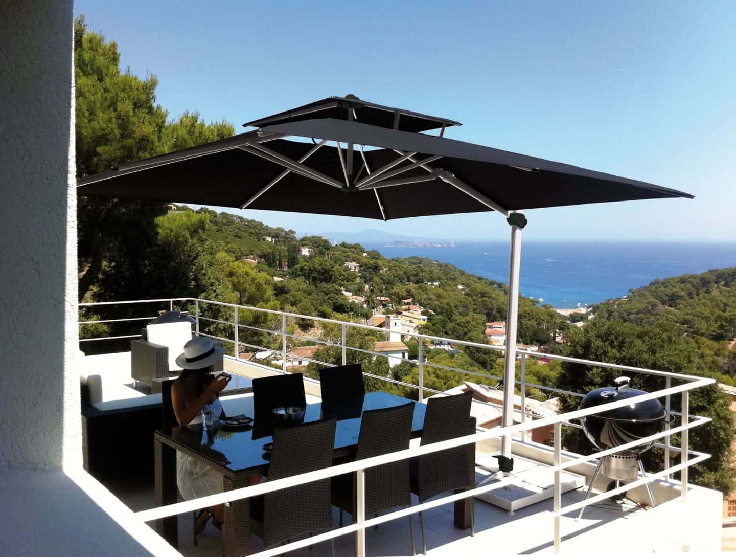 Garden Parasol from Solero Parasols. Large black square cantilevered parasol providing shade over a garden dining set.