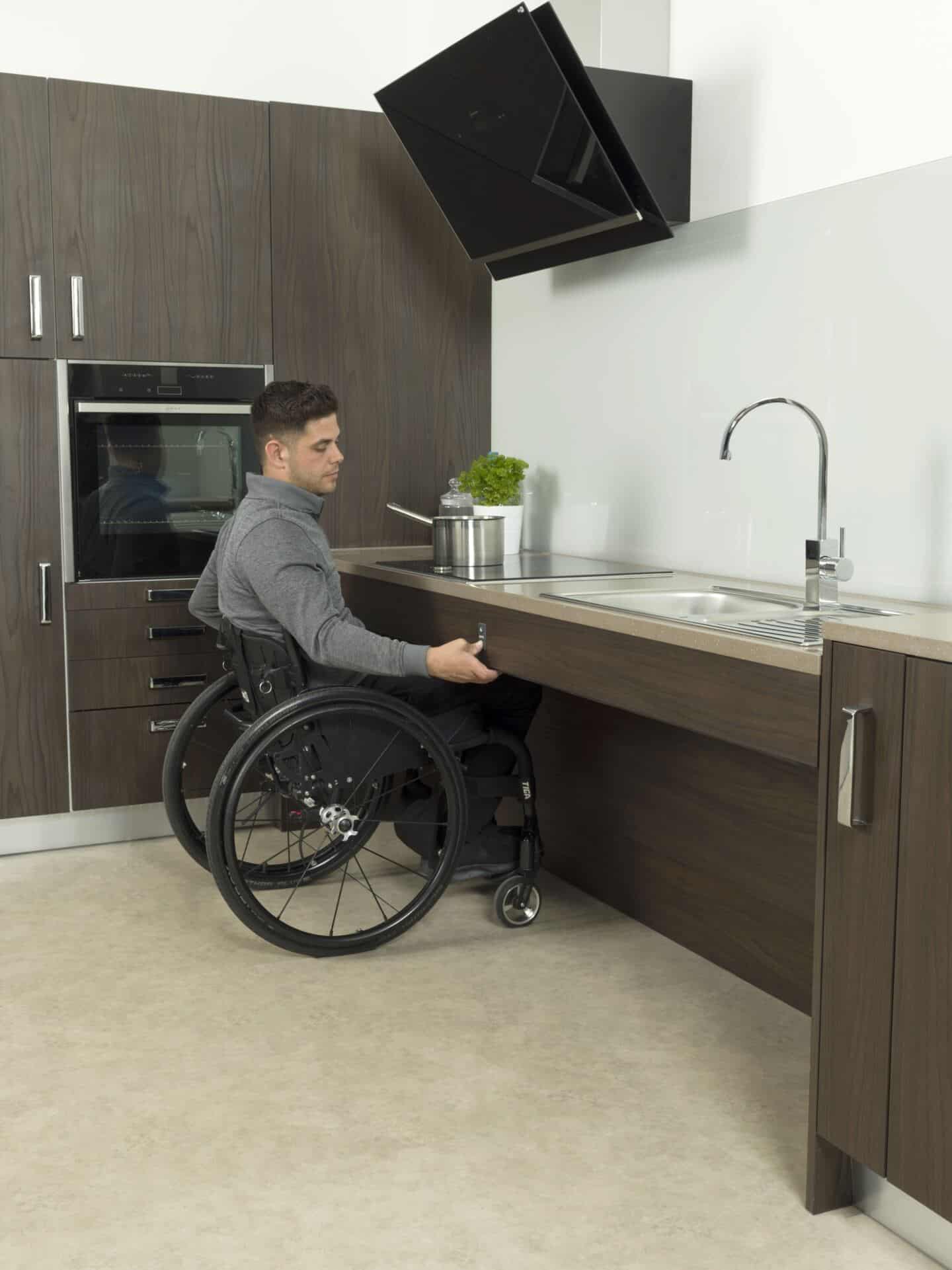 A man in wheelchair cooking in an accessible Freedom kitchen by Symphony