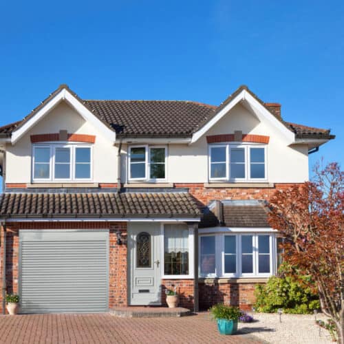 A detached red brick house with integrated garage