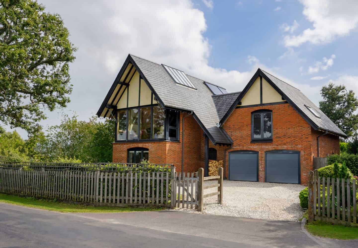 A detatched red brick house with pitched roof and double garage
