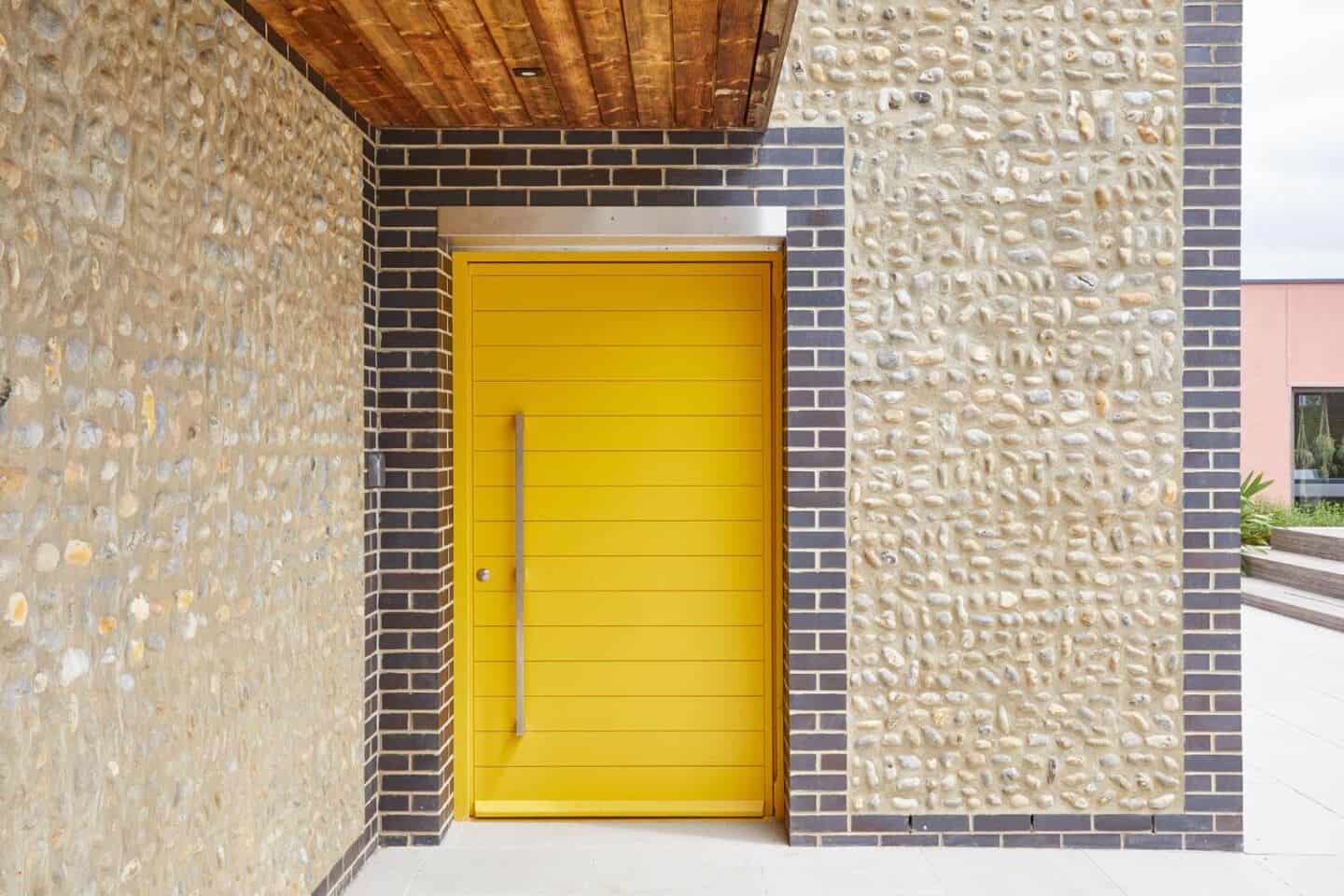 A modern home with a bright yellow contemporary front door