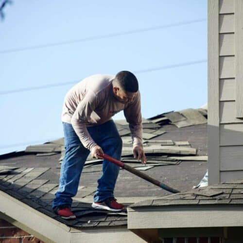 A man on a roof repairing the tiles