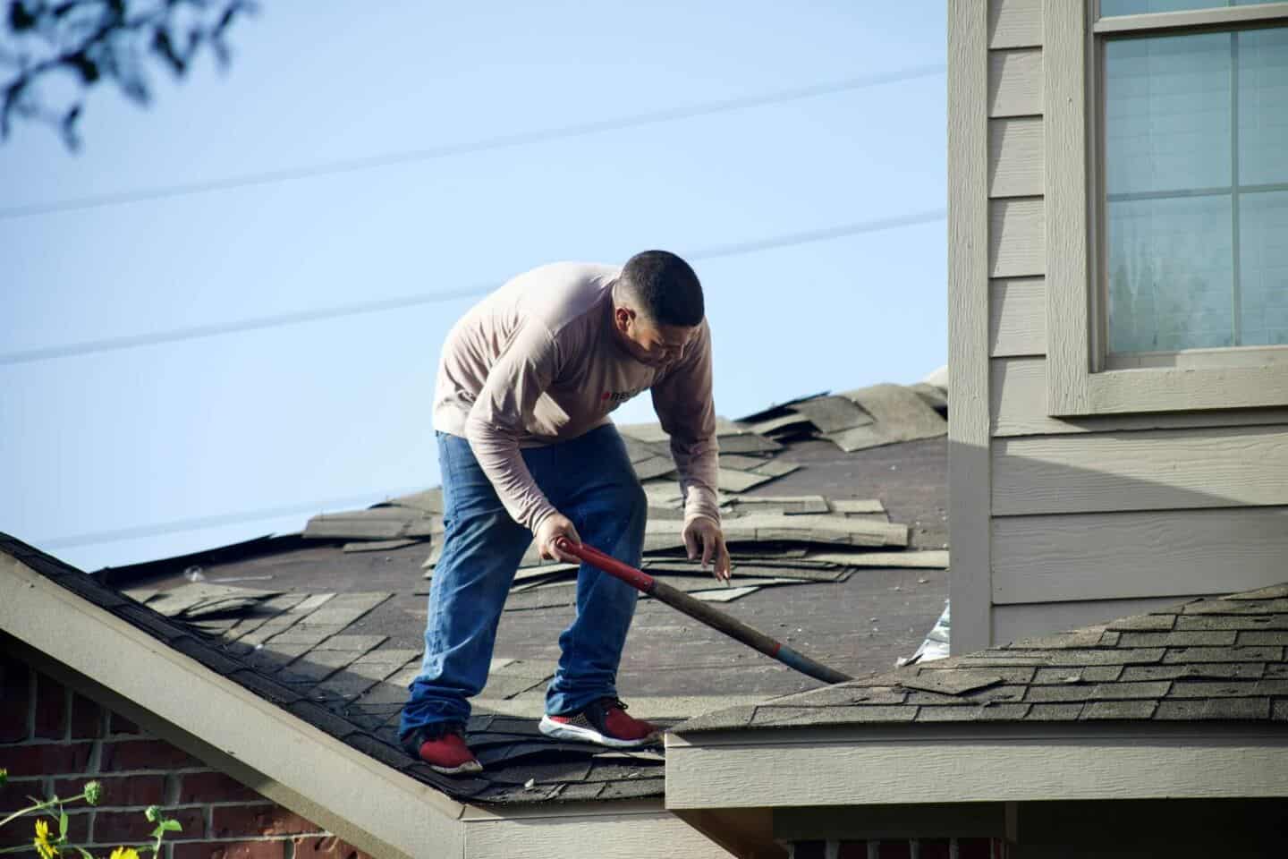 A man on a roof repairing the tiles